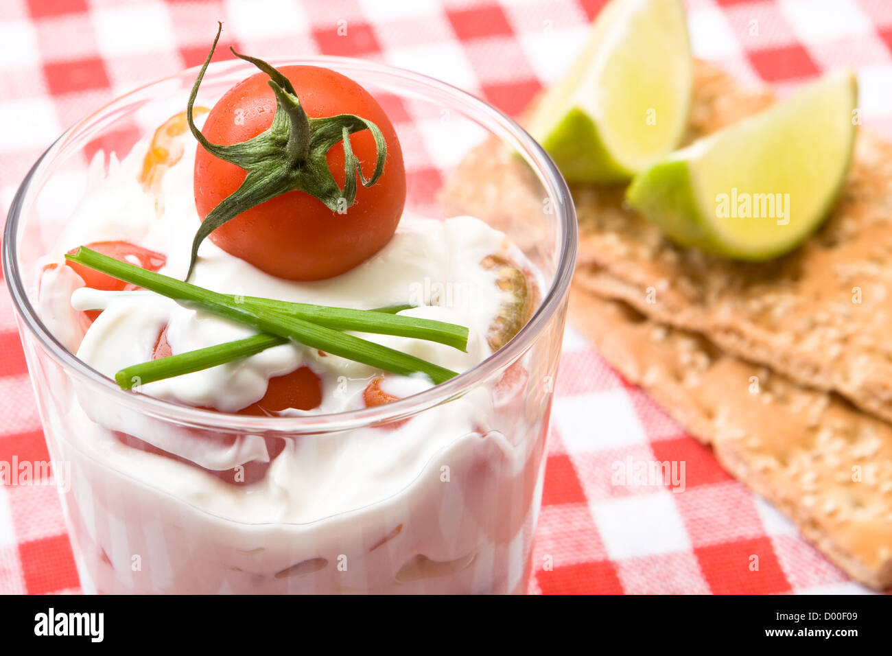 Bicchiere di quark, yogurt e di pomodori tagliati a pezzi Foto Stock