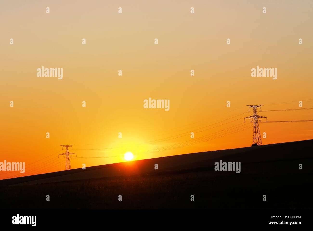 Tensione alta tralicci e sfondo al tramonto Foto Stock