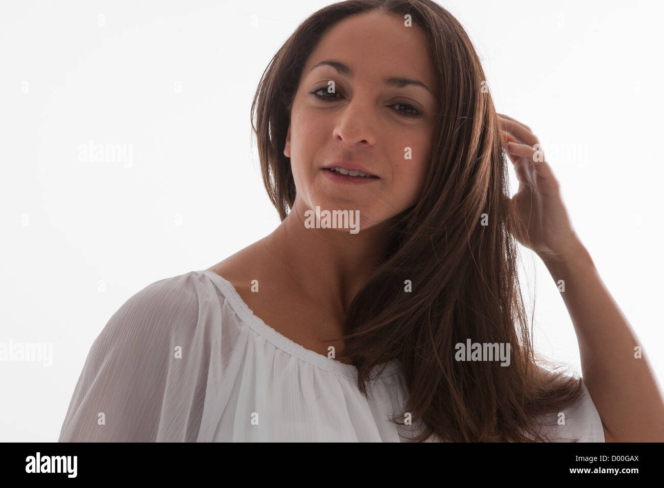 Real giovane bella donna di toccare i capelli Foto Stock