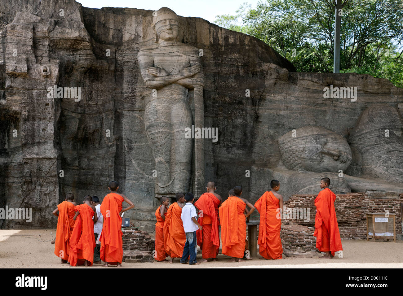 Il debuttante monaci contemplando la roccia scolpita Buddha. Gal Vihara. Polonnaruwa antica città. Sri Lanka Foto Stock