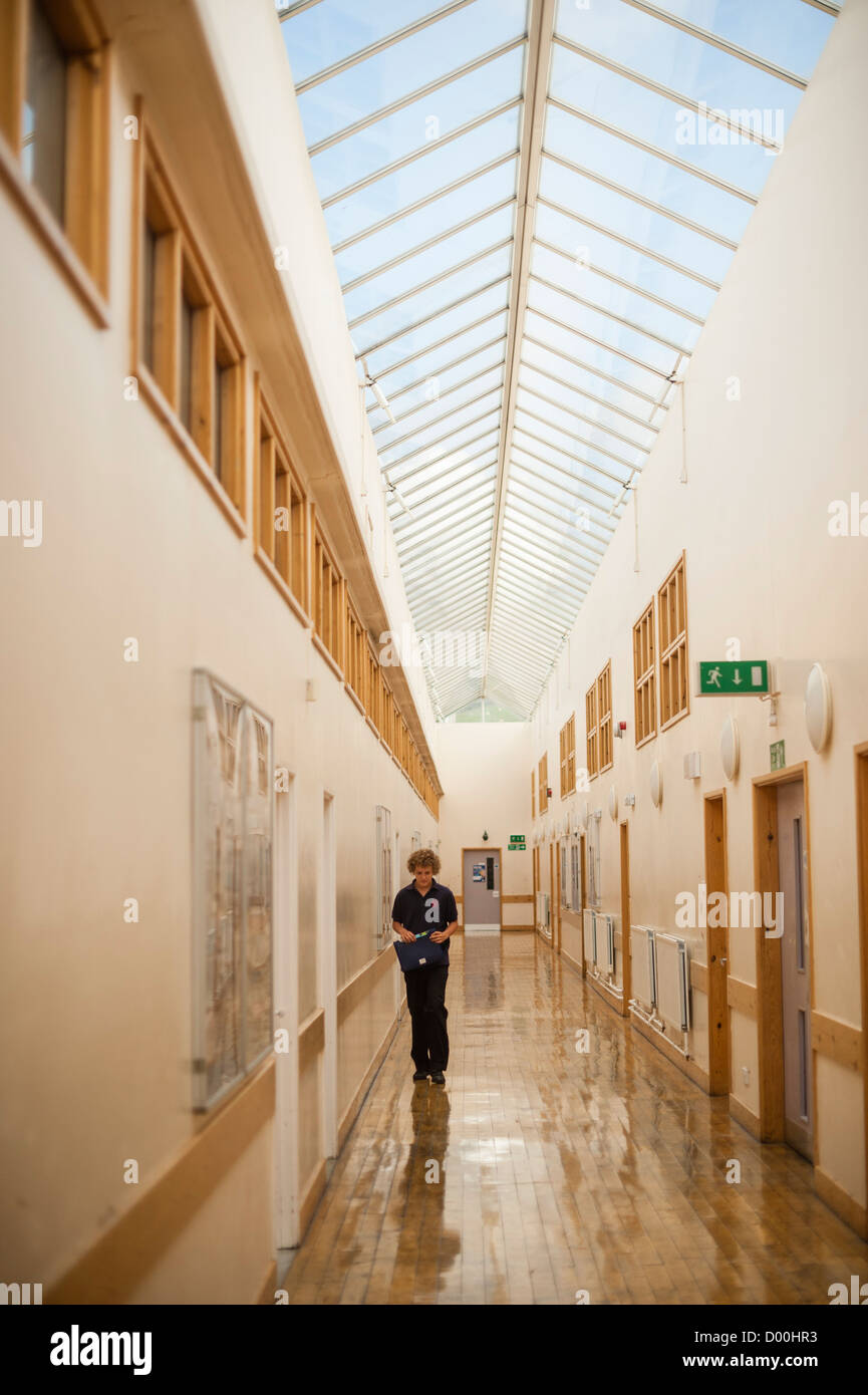 Un allievo della scuola a piedi nel corridoio tra le lezioni presso un secondario completo scuola, Wales UK Foto Stock