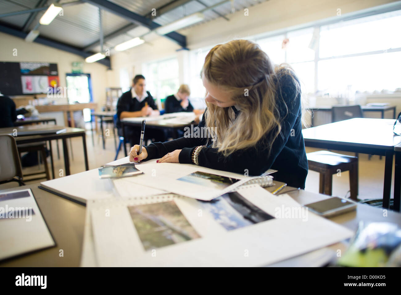 Una ragazza adolescente anno 12 13 lavora in un livello di una lezione di arte presso un secondario completo scuola, Wales UK Foto Stock