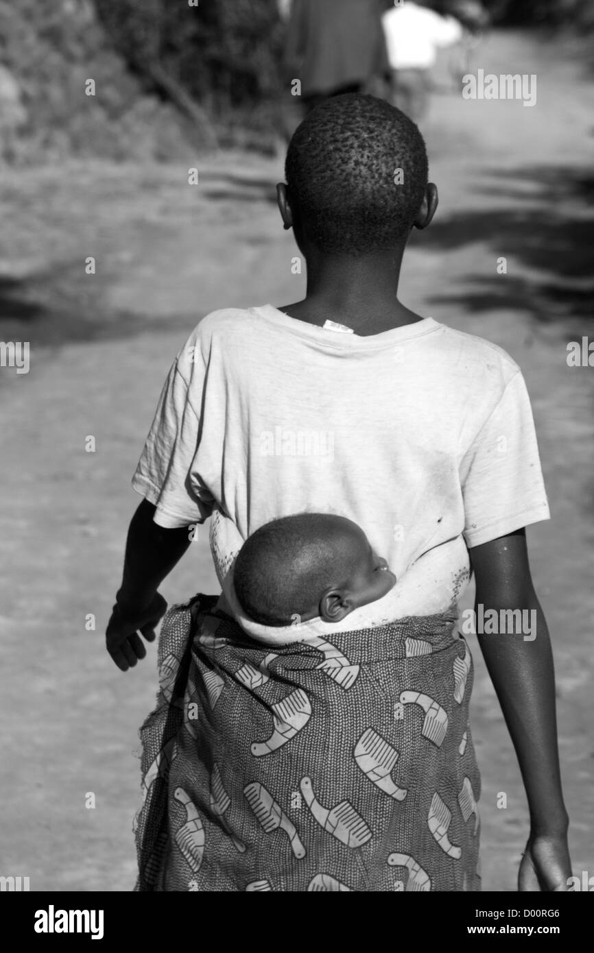 Donna cura il suo bambino sulla schiena. Foresta impenetrabile di Bwindi, Parco Nazionale, Uganda Foto Stock