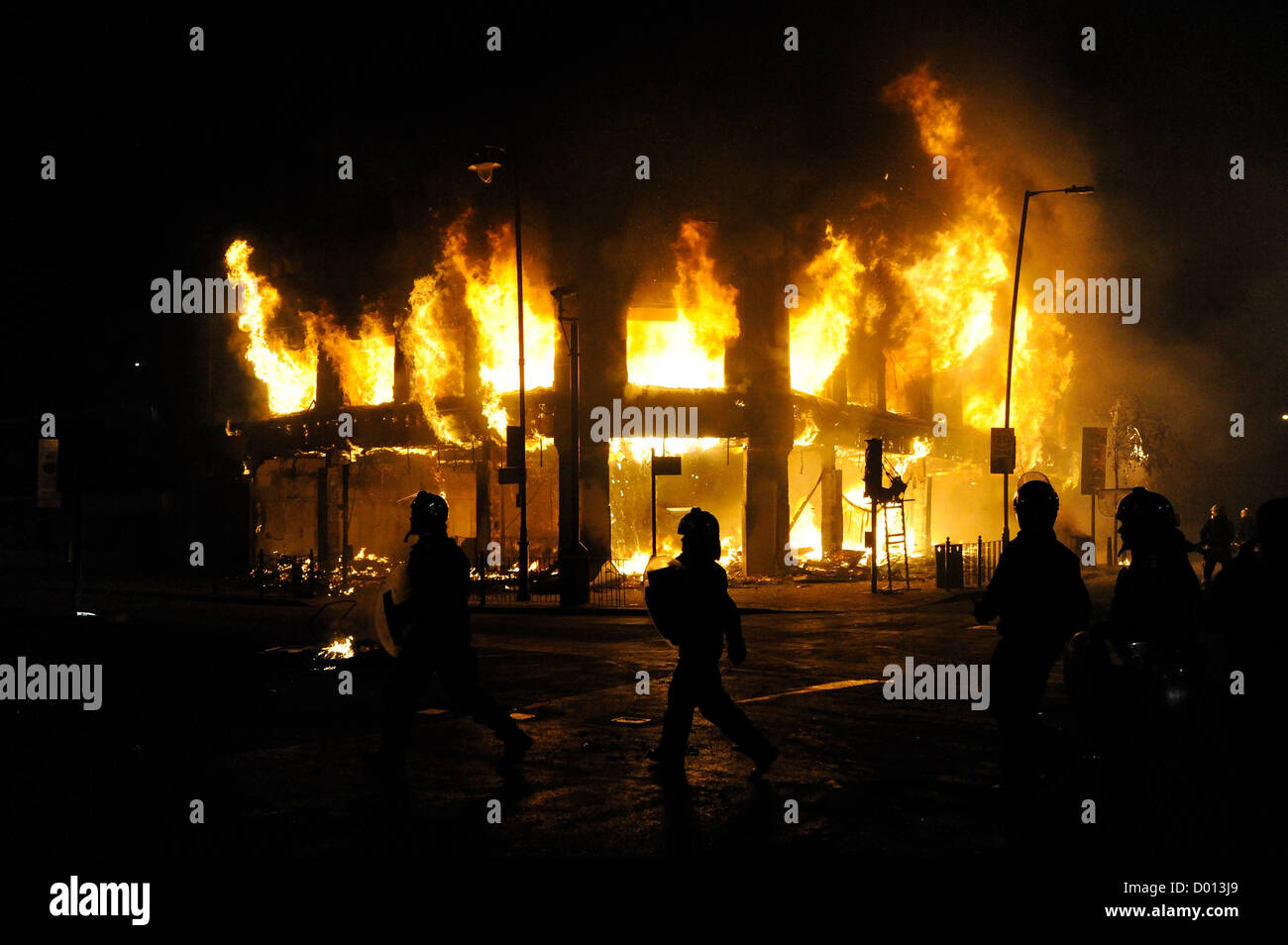 Gli ufficiali di polizia eseguire la masterizzazione del passato store in Tottenham High Road Londra Foto Stock