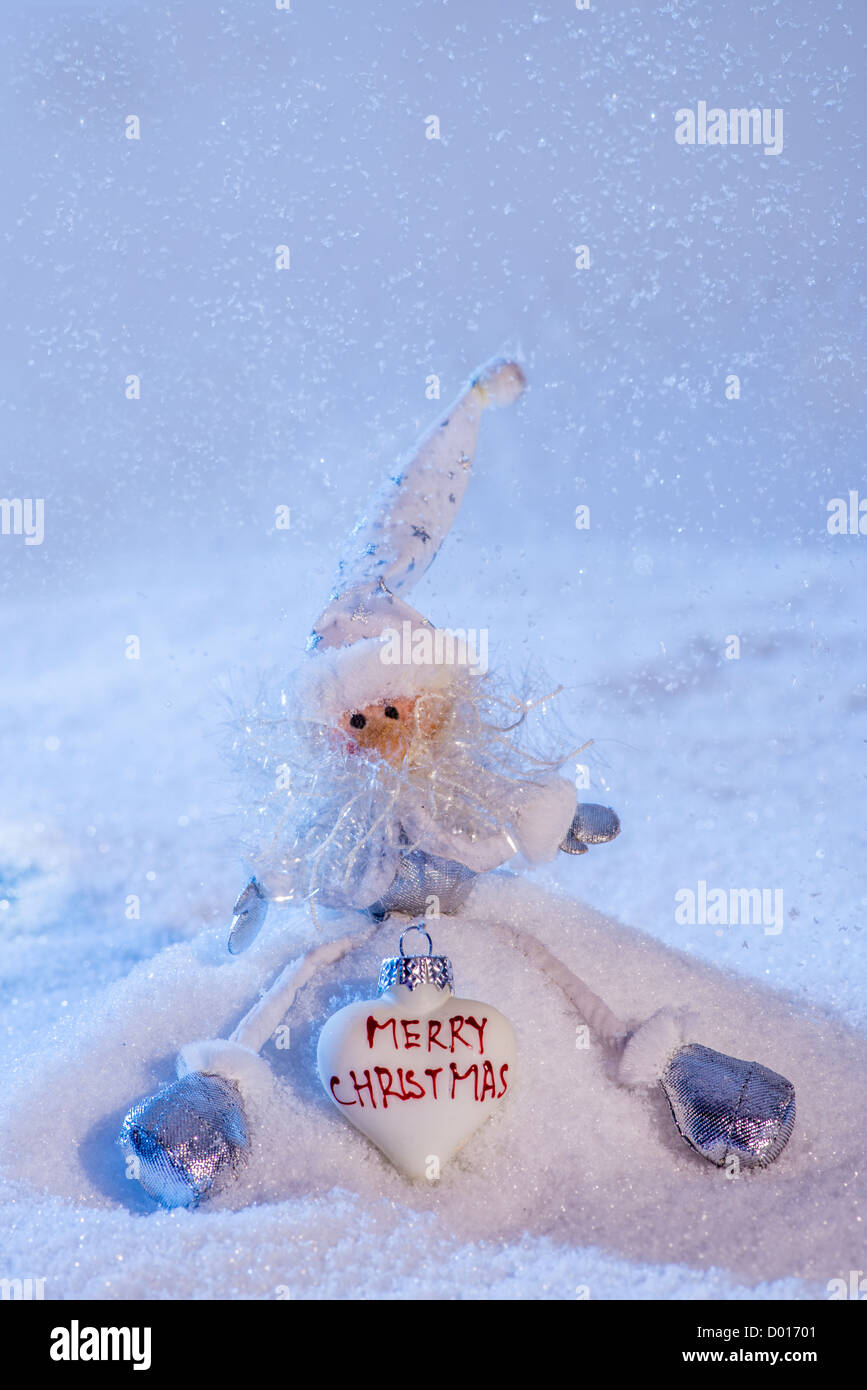 Babbo Natale seduto sulla neve e vi augura Buon Natale. Copia dello spazio. Foto Stock