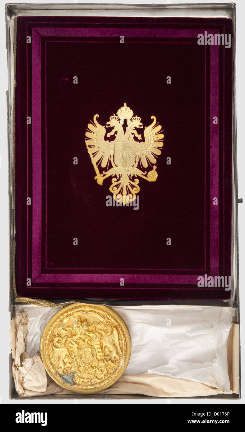 Un brevetto di nobiltà, per Franz Ritter von Pitha, che concede il titolo di Freiherr(barone). Documento sul vellum con testo calligrafico e ricche illustrazioni, tra cui uno stemma policromo, l'ultima pagina con la data 1875, e le firme dell'imperatore Franz-Joseph e Freiherr von Laßner-Zollheim. Copertura in velluto viola con aquila araldica applicata in oro. Scatola di tenuta dorata, coperchio con i bracci imperiali in rilievo. Con custodia in lamiera di ferro stagnata, 31 x 53 cm, cerniera aperta. Documento in ottime condizioni, storico, storico, 19 ° secolo, imperiale,, diritti aggiuntivi-clearences-non disponibile Foto Stock