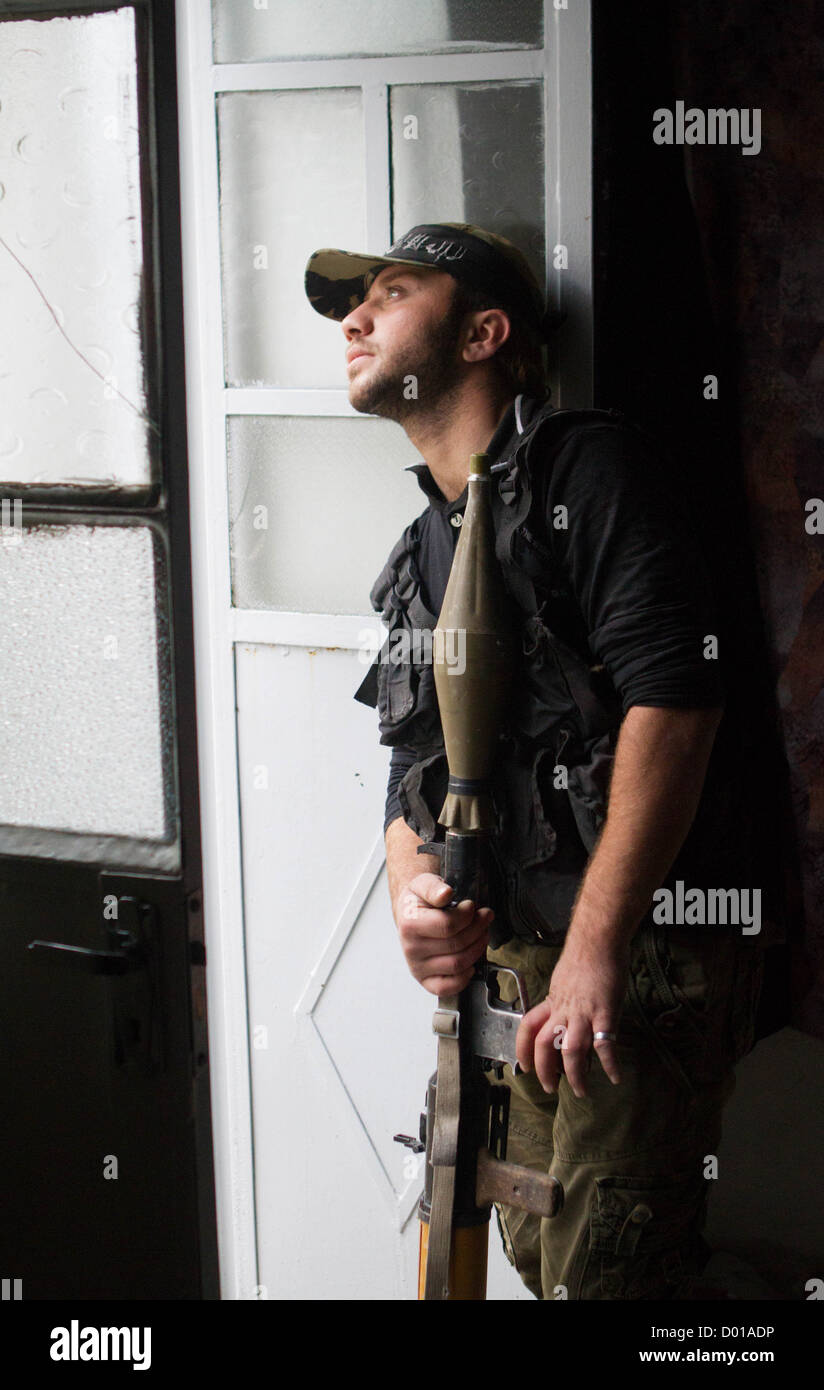 Aleppo, Siria: un libero esercito siriano gli stati con un RPG lanciarazzi granata guarda da una posizione sicura in Safa. Foto Stock