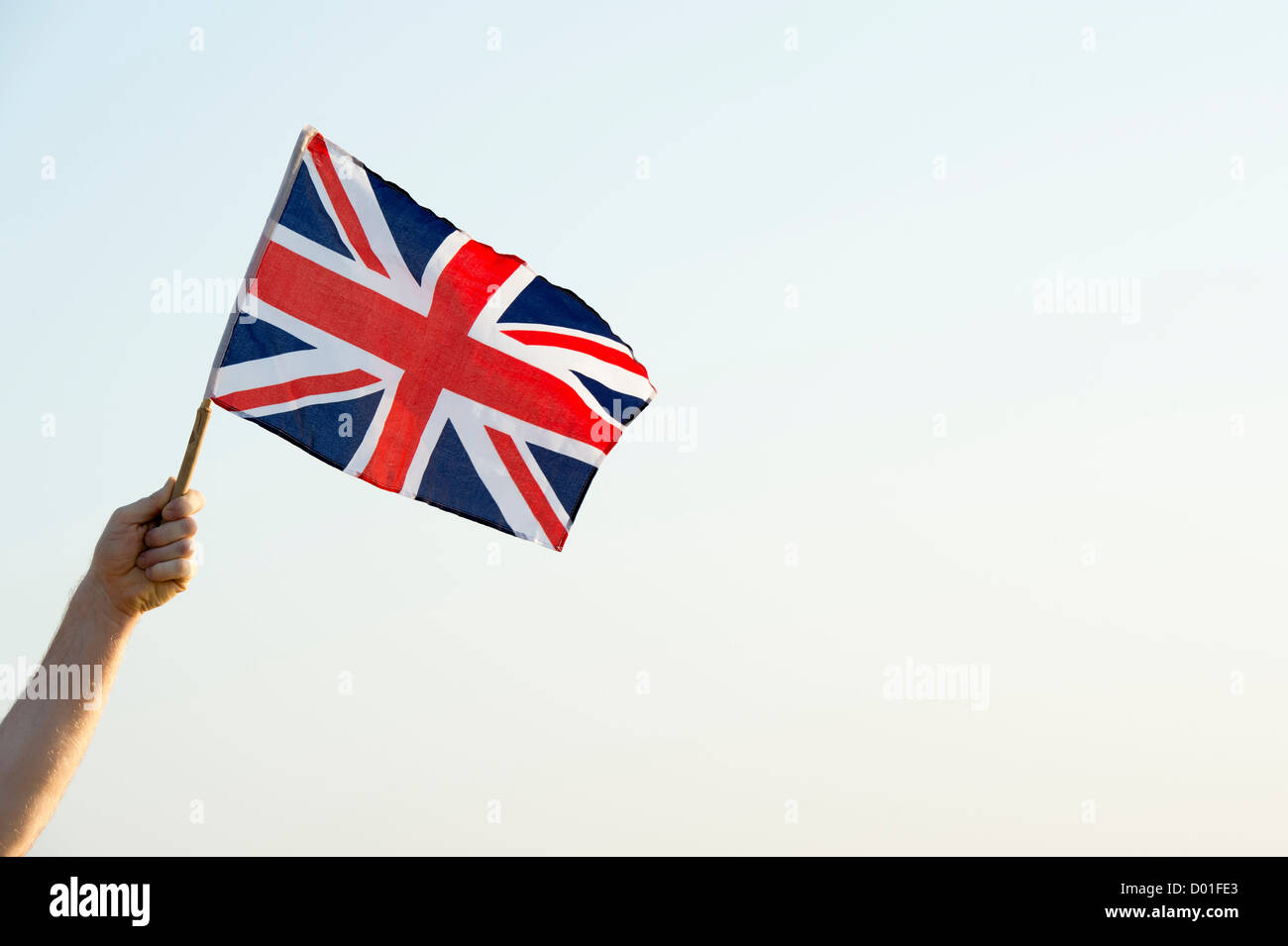 Mano che tiene una bandiera dell'Union Jack Foto Stock