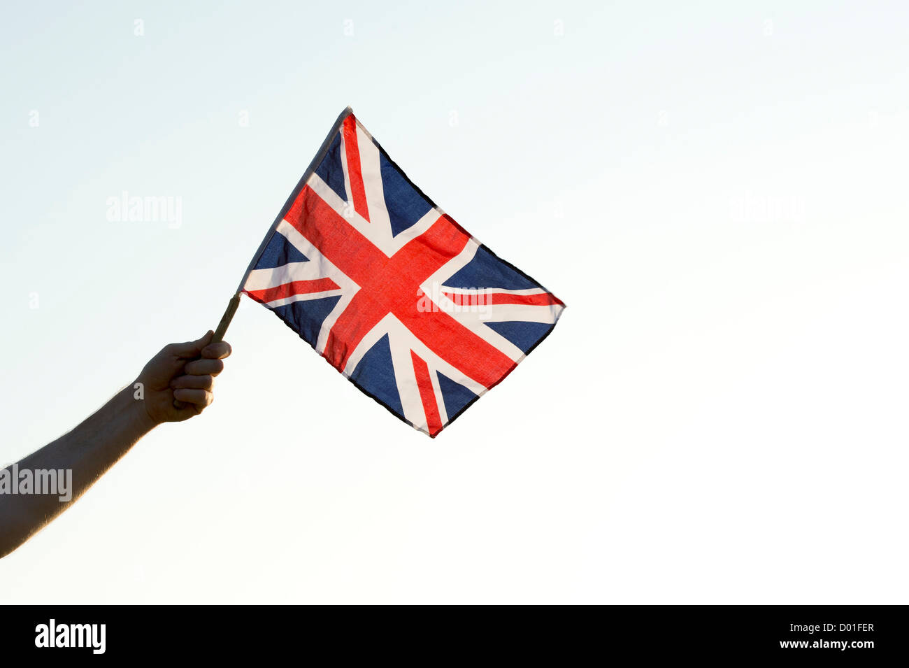 Mano che tiene una bandiera dell'Union Jack Foto Stock