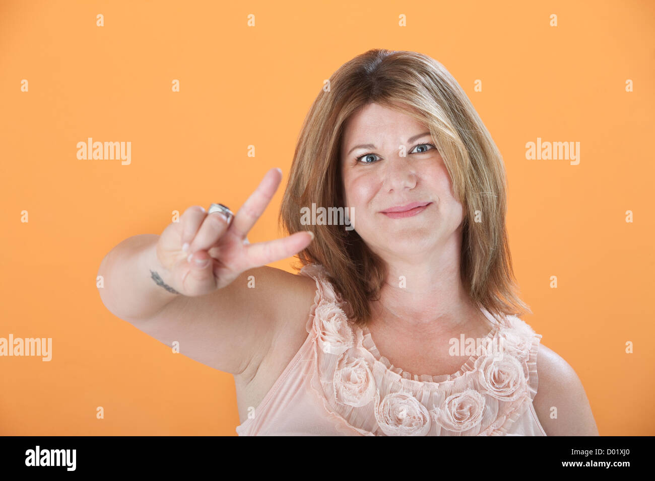 Matura donna caucasica mostra il simbolo della vittoria Foto Stock