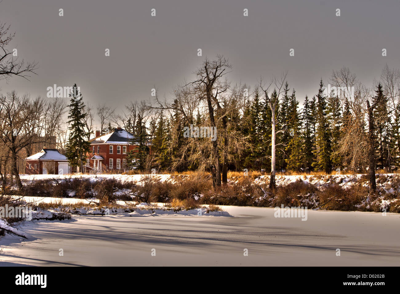 Vecchia casa di mattoni HDR pic con alberi e un laghetto congelato Foto Stock