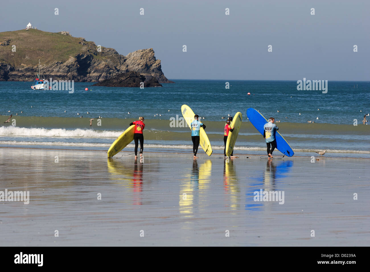 Surfers che fa i loro esercizi di pre-surf con il loro istruttore a Newquay, Cornovaglia, Inghilterra sud-occidentale Foto Stock