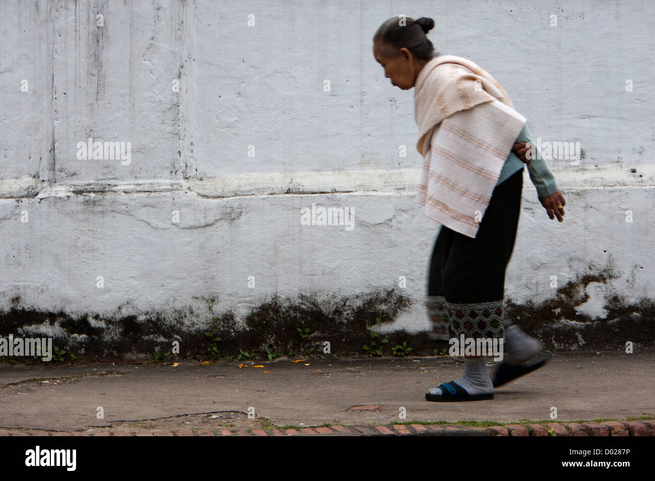 Donna anziana in scialle camminando Luang Prabang Laos Foto Stock