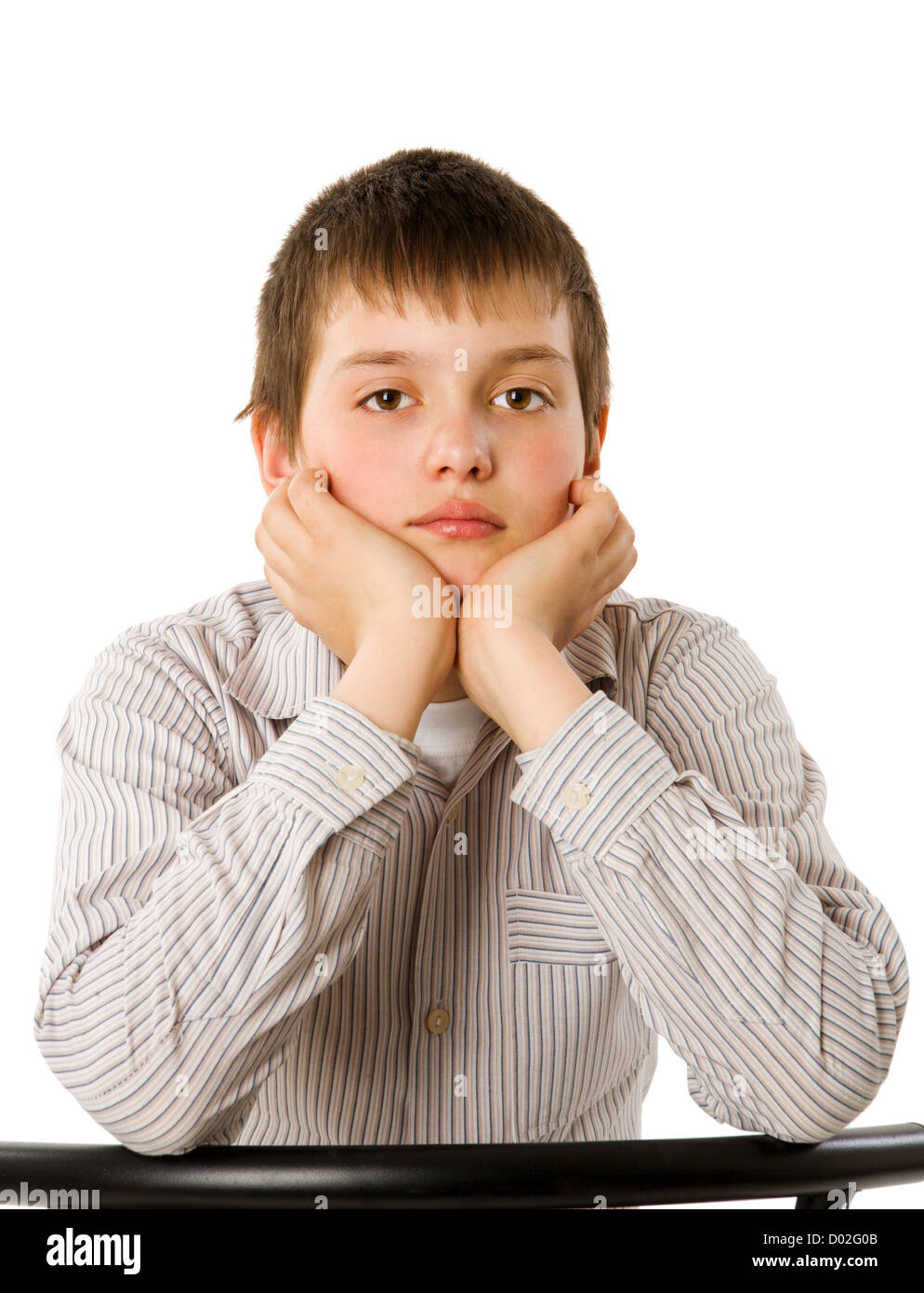 Annoiato dieci anni ragazzo seduto isolato su bianco Foto Stock