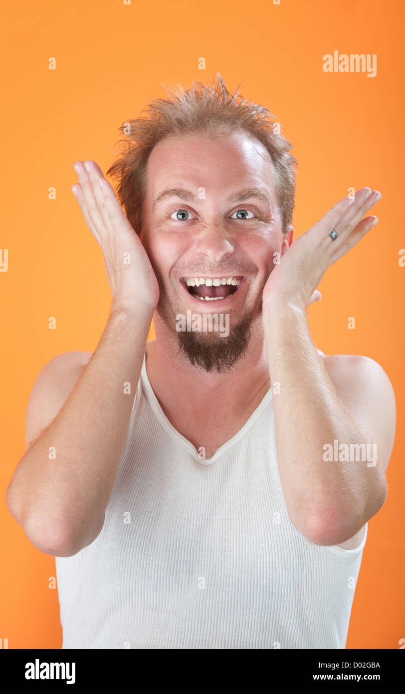 Poveramente vestito uomo a ridere con le mani sul suo volto Foto Stock