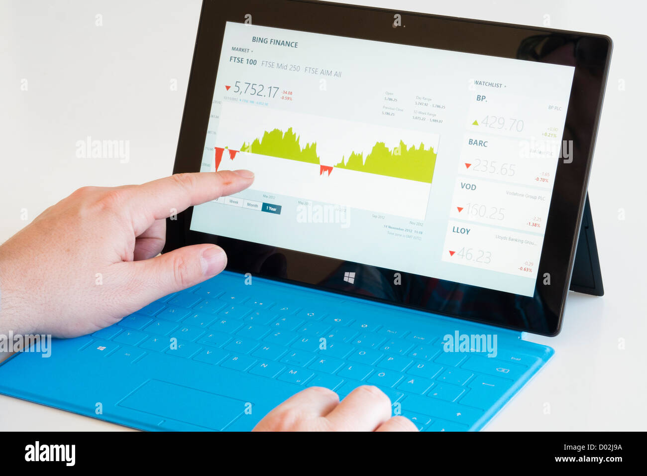 L'uomo controllo notizie finanziarie su Microsoft Surface rt computer tablet Foto Stock