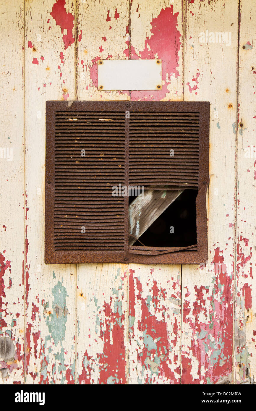 Vecchio arrugginito lo sfiato di aria in un vecchio peeling sfondo della porta Foto Stock