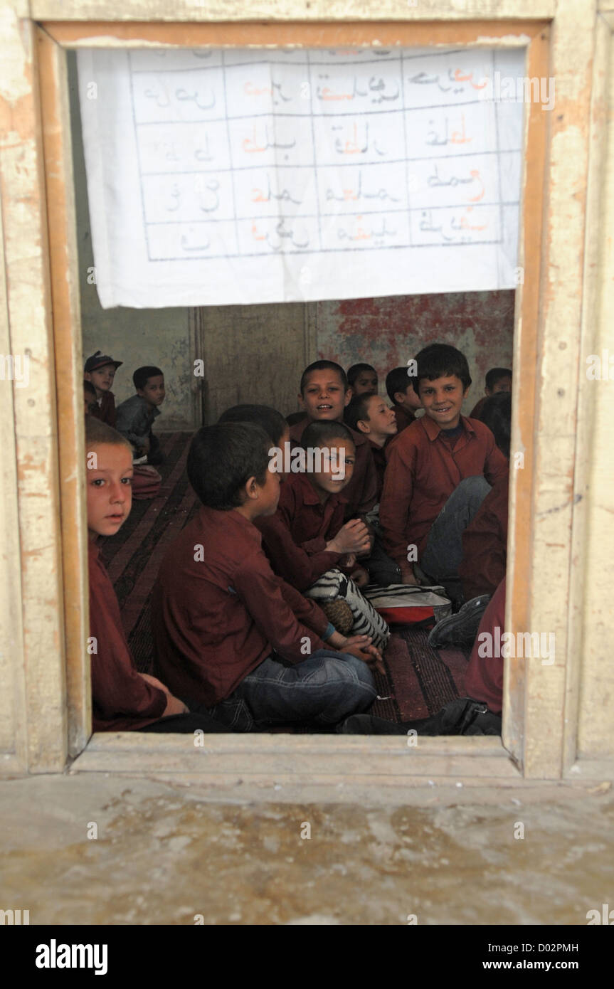 Bambini afgani a boys school attendere per una visita da parte di membri della Forza internazionale di assistenza alla sicurezza Settembre 18, 2008 a Kabul, Afghanistan. L'ISAF aiuta la comunità fornendo forniture scolastiche, vestiti e cibo per le agenzie locali in stato di bisogno. Foto Stock