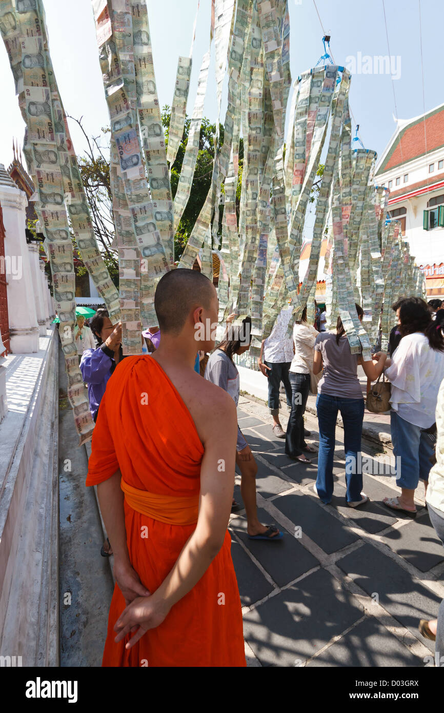 Monaco guarda le donazioni di denaro a una stringa nel tempio di Wat Arun a Bangkok, in Thailandia Foto Stock
