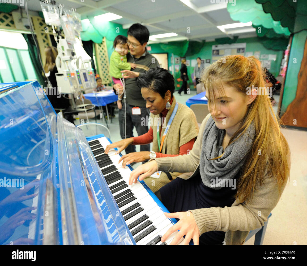 Novembre 15, 2012. Toronto, Canada. Sensazione di pianoforte Marika Bournaki esegue in ospedale per i bambini malati prima del Toronto premiere di 'Io non sono una Rock Star". Il film documentario segue Marika la carriera di età da 12 a 20 verrà prima presso il Bloor Cinema venerdì 16 novembre, 2012. Marika svolgerà un breve recital presso la premiere su un baby grand piano, un primo gran pianoforte presso il Bloor Cinema. Nella foto, Marika Bournaki con baby Avery e SickKids' musica terapista Carolyn Williams. (DCP/N8N) Foto Stock