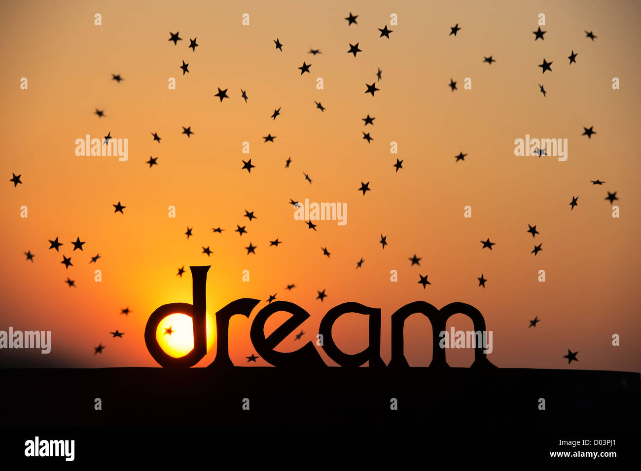 Silhouette parola da sogno e stelle cadenti al tramonto con Sun in D Foto Stock