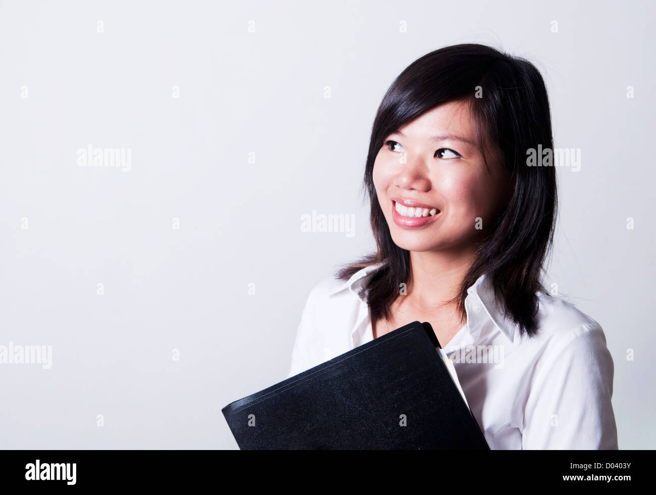 Giovane donna asiatica guardando al lato luminoso. Foto Stock
