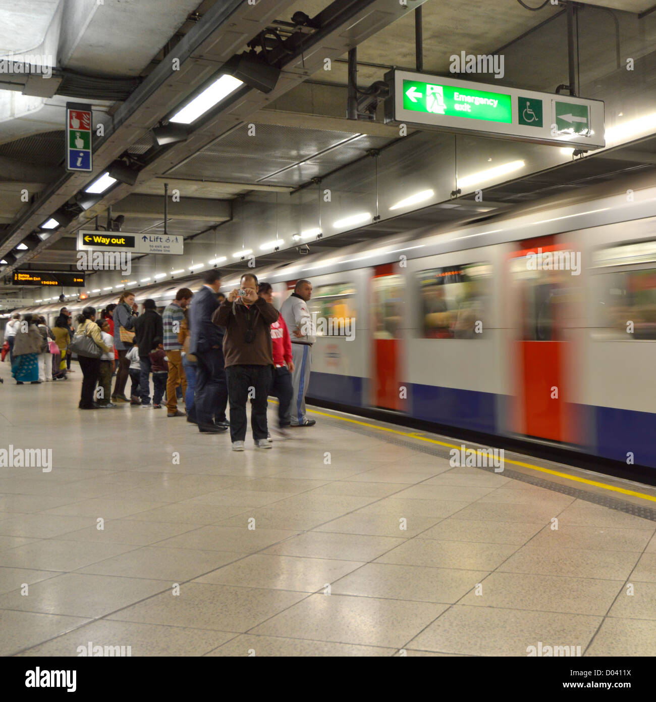 Metropolitana di Westminster tube station piattaforma e motion blur treno in arrivo Foto Stock