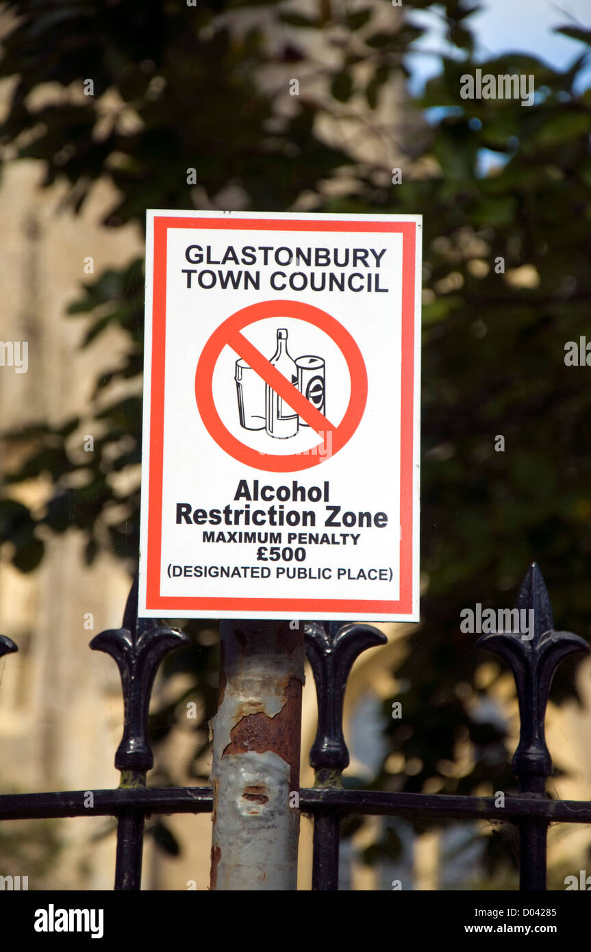 L'alcol zona di restrizione segno da parte della città di Glastonbury di avvertimento del consiglio di ammenda per bere nei giardini della chiesa e la strada Foto Stock