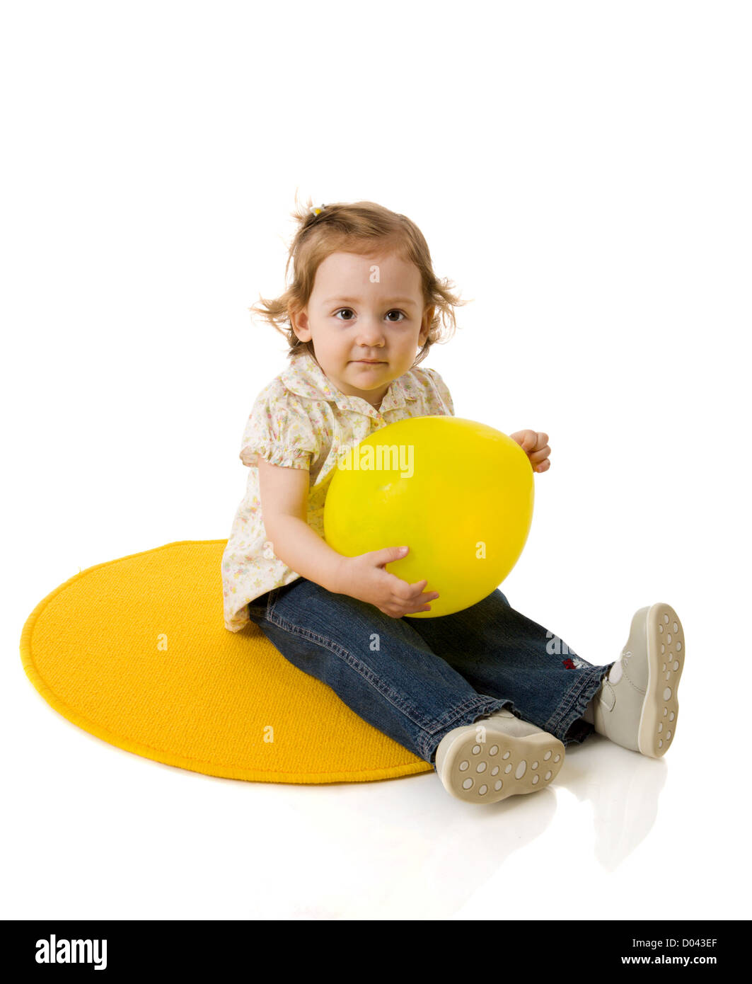 Due anni ragazza seduta holding balloon isolato su bianco Foto Stock