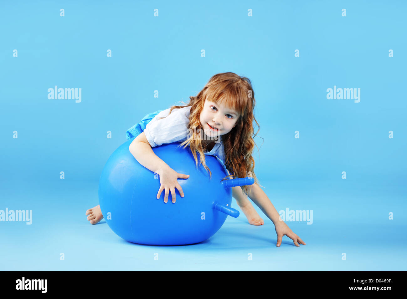 Bambino con palla ginnica su bleu di sfondo per studio Foto Stock
