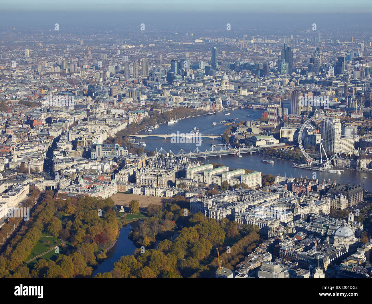 Guardando ad est di Londra lungo il Tamigi per la città con il St James Park e il London Eye e Whitehall in primo piano Foto Stock
