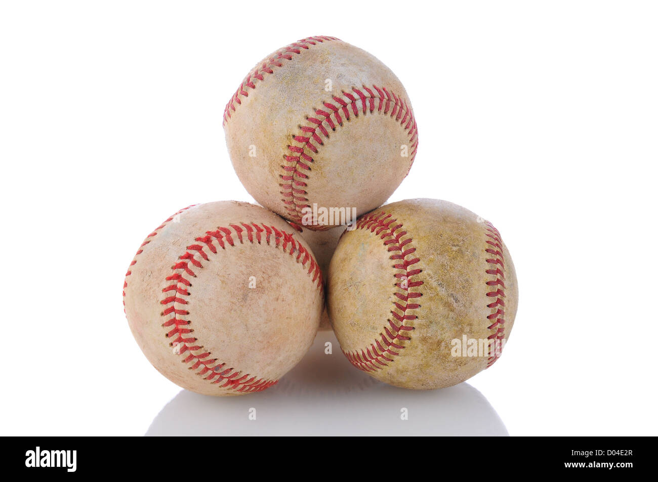 Primo piano di una pila di ben utilizzati baseballs. Formato orizzontale su uno sfondo bianco con la riflessione. Foto Stock