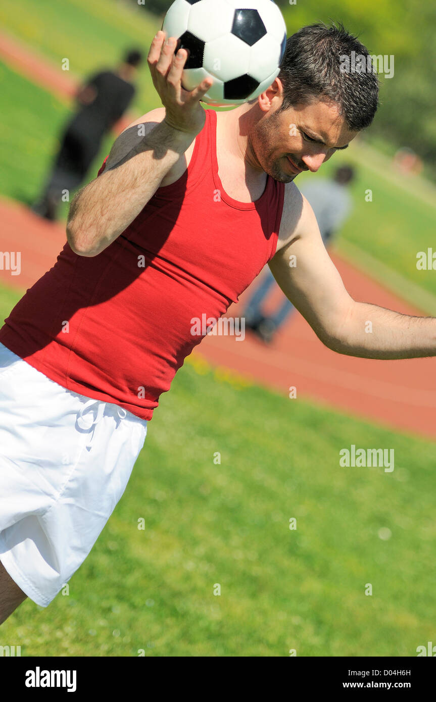 Attraente giocatore di football di bianco e nero con palloncino Foto Stock