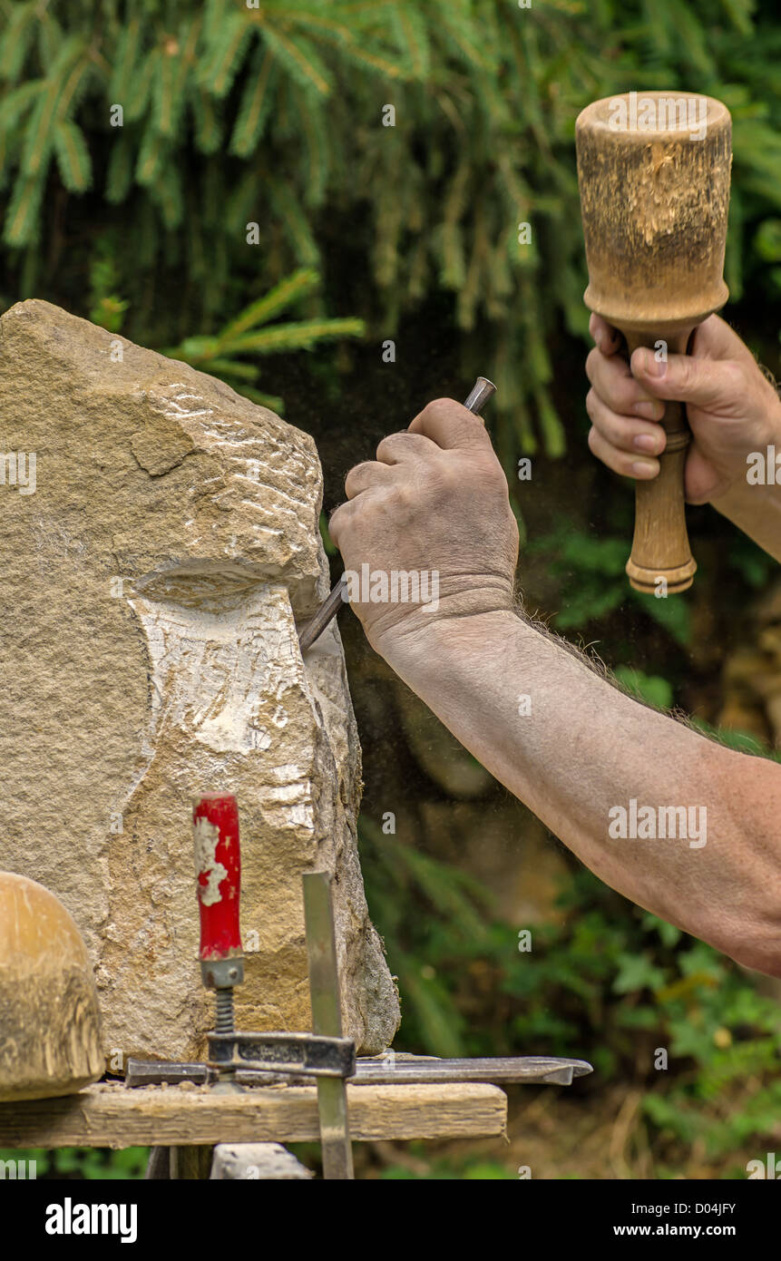 Scultore lavorando su una scultura in pietra Foto Stock