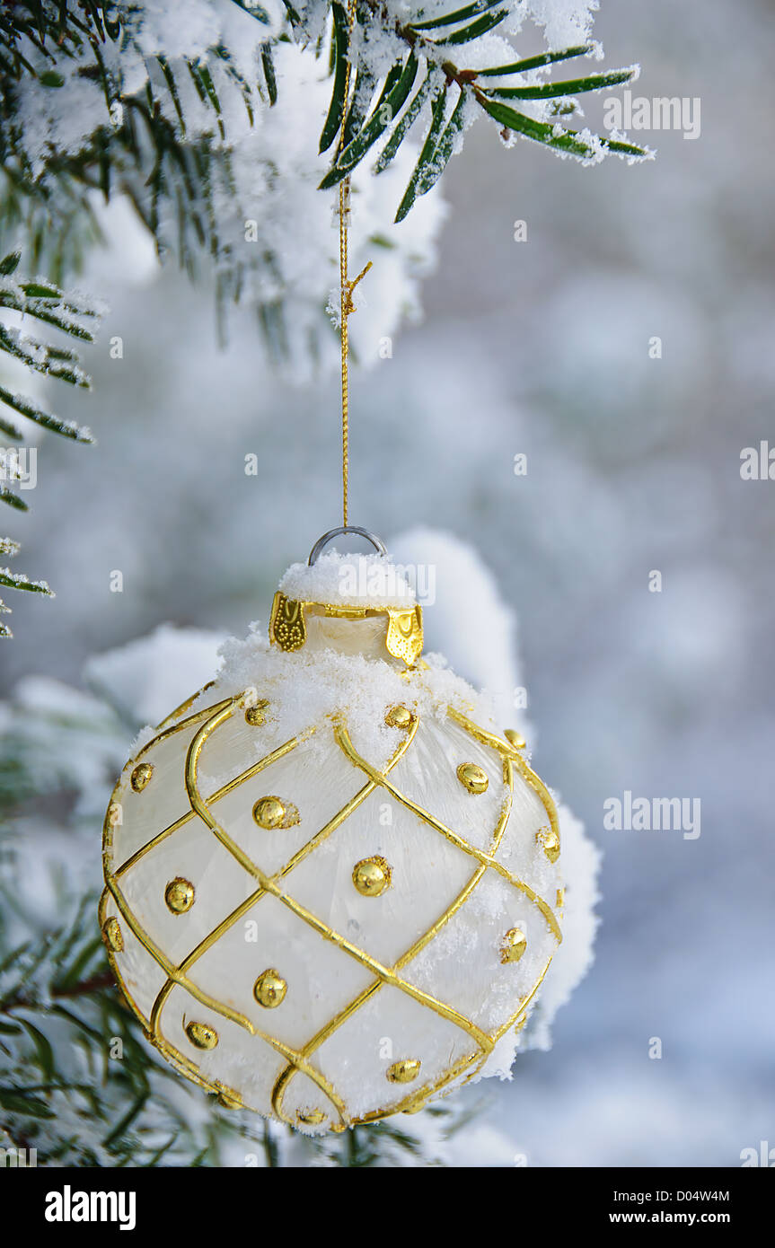 Un bianco lampadina di Natale, appeso a una coperta di neve tree Foto Stock Un bianco lampadina di Natale, appeso a una coperta di neve tree Foto Stock