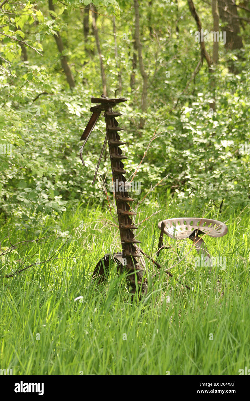 Un antico coperto di ruggine cavallo e taglio di erba abbandonato in un prato in primavera a Altona, Manitoba, Canada Foto Stock