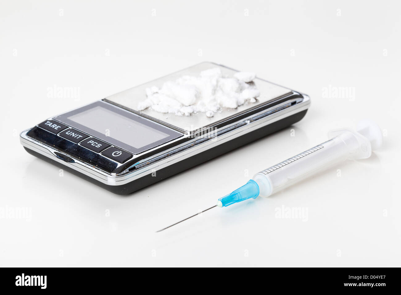 La siringa e la bilancia digitale con farmaci closeup su sfondo bianco Foto Stock