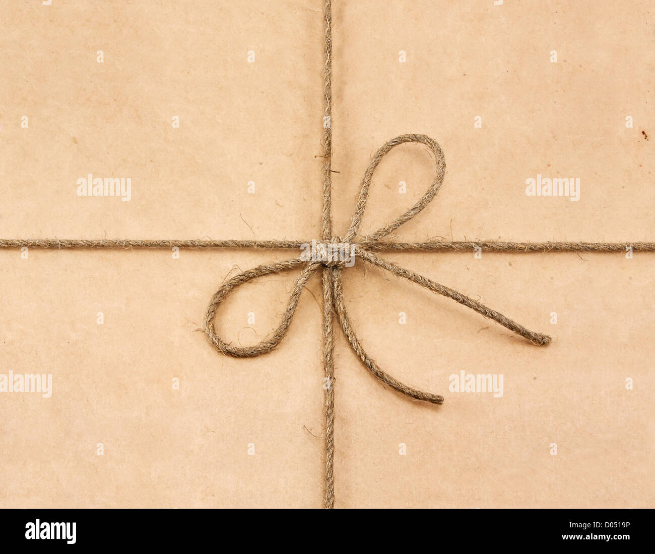 Stringa legato in un arco sulla carta riciclata marrone Foto Stock