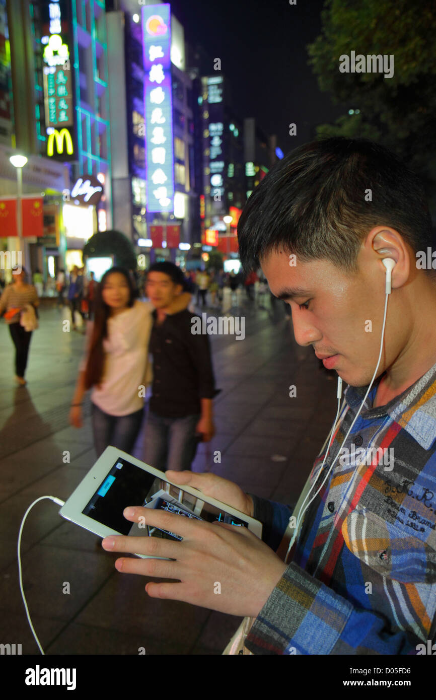 Shanghai Cina, quartiere cinese Huangpu, East Nanjing Road, strada pedonale, uomo asiatico uomini maschio adulti, notte, giorno nazionale settimana d'oro, tablet, Appl Foto Stock