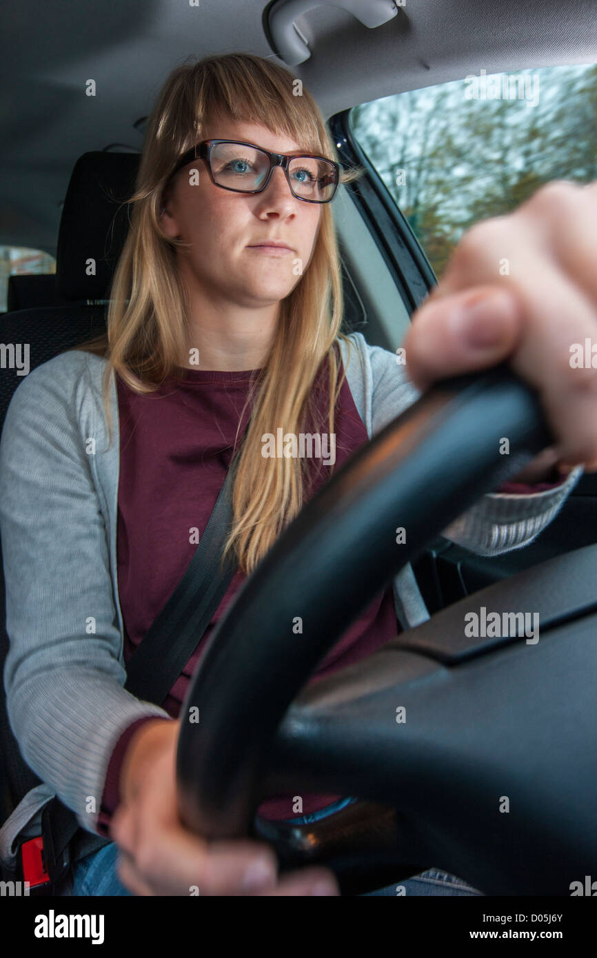 La donna è alla guida di un'auto. Foto Stock