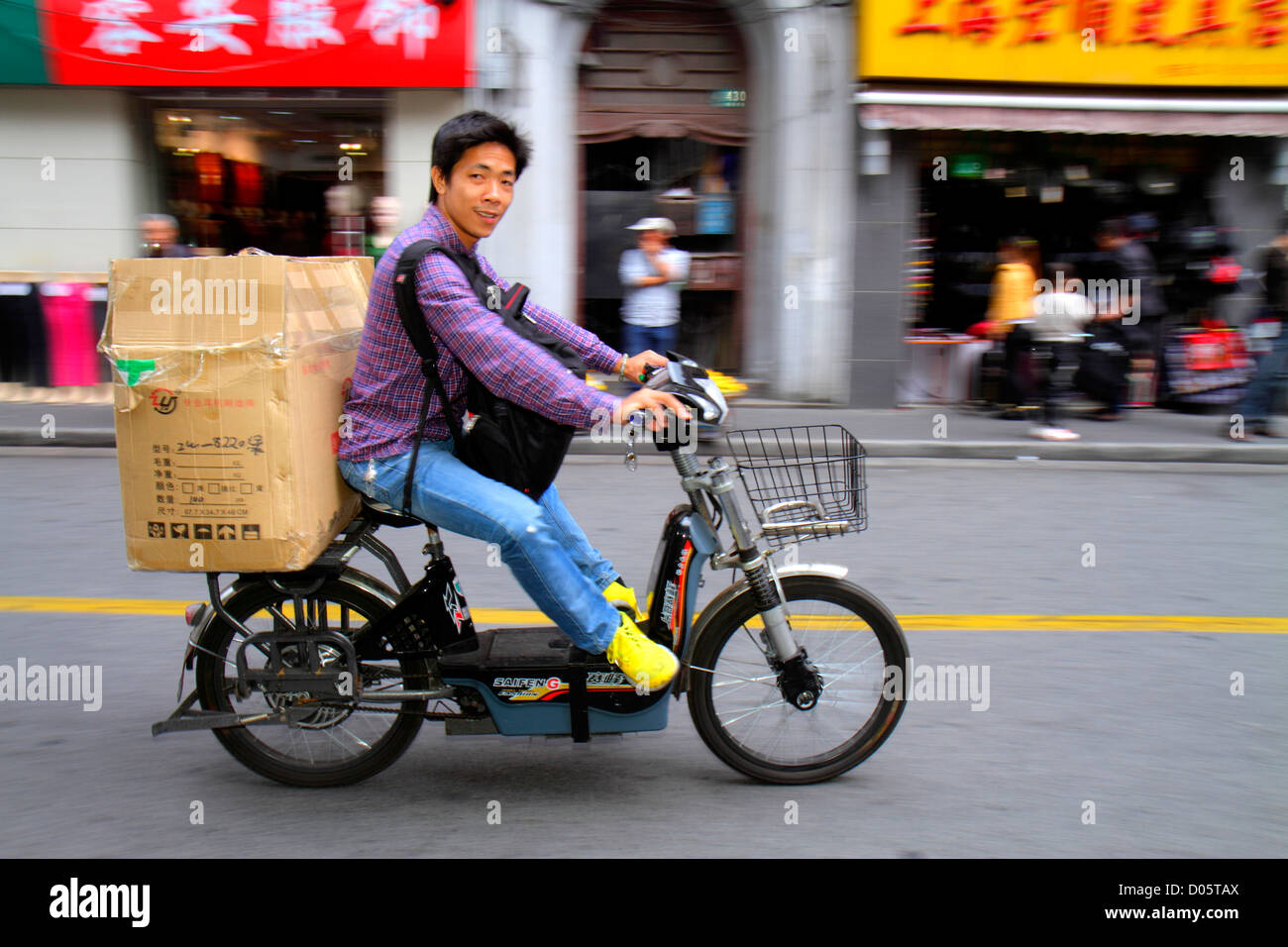 Shanghai Cina, cinese Huangpu District, Sichuan Road, uomo asiatico uomini maschio adulti, moto elettrico scooter bici, equitazione, senza casco, box, Mandarin, hanzi, c Foto Stock