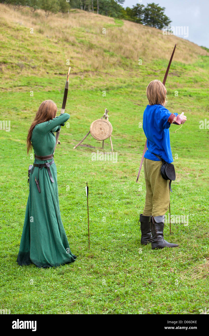 Donna e uomo tiro con arco e frecce a viking festival in Norvegia occidentale. Foto Stock