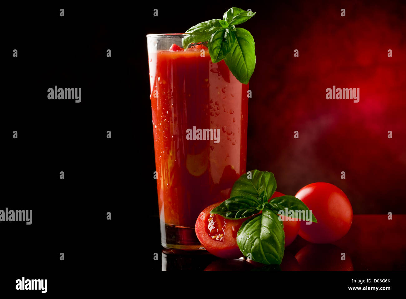 Foto di deliziosa pomodoro bloody mary cocktail riflettendo sul tavolo di vetro con la luce spot Foto Stock