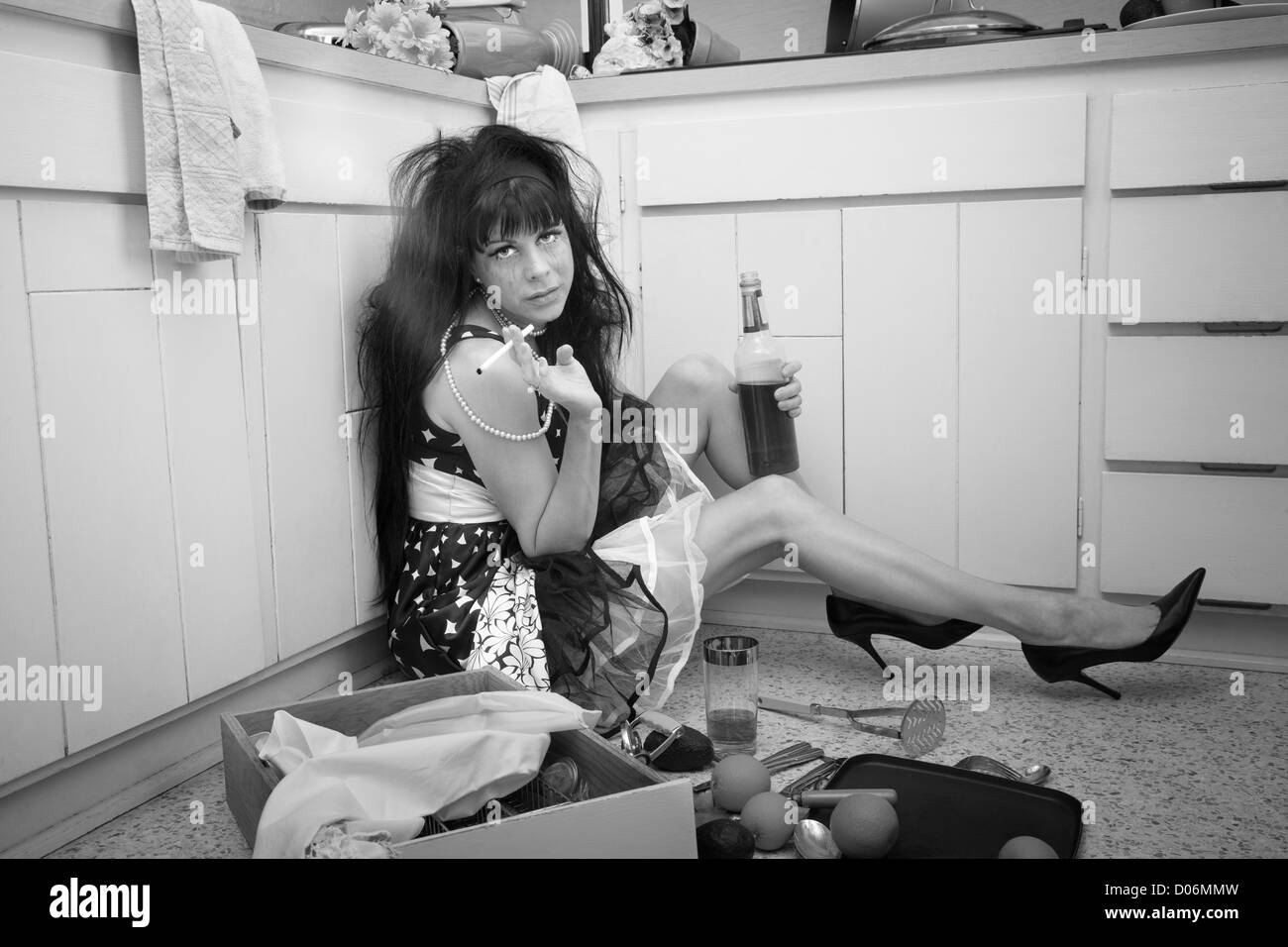 Carefree donna sul pavimento della cucina fuma e bevande Foto Stock