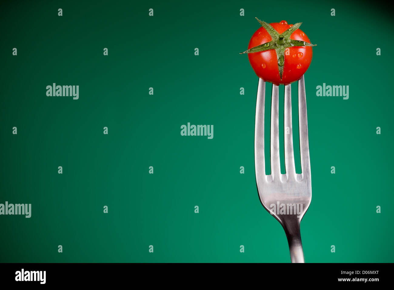 Primo piano della forcella con il pomodoro su sfondo blu Foto Stock