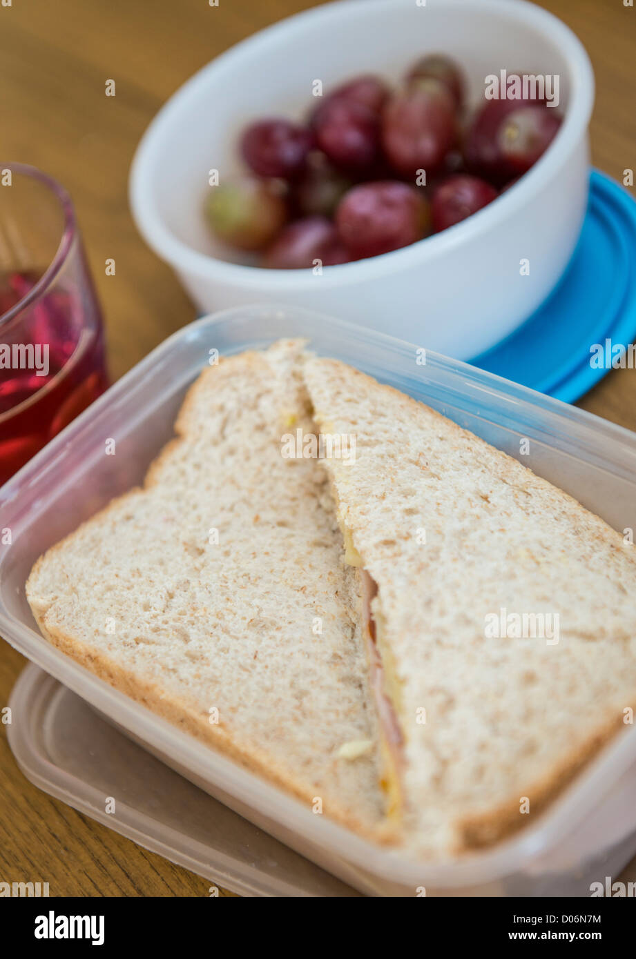 Panini e una pentola di uve per il pranzo in una casella a sandwich. Foto Stock