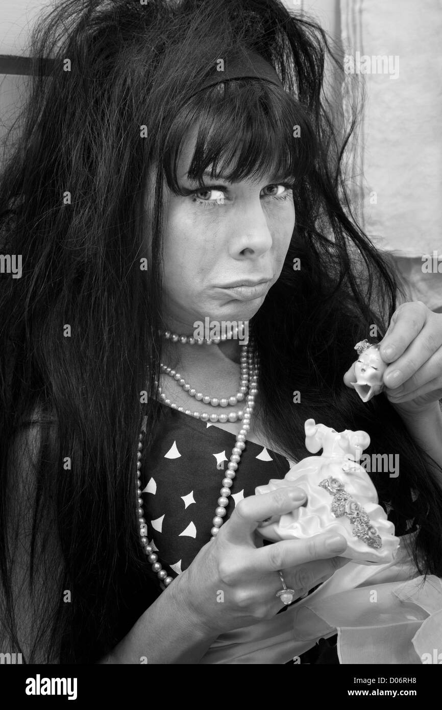 Nero infelice dai capelli donna con broken doll piange Foto Stock