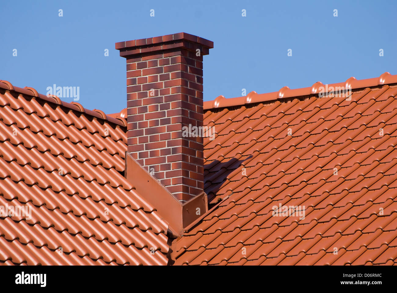 File di tegole rosse del tetto in foglio con camino Foto Stock