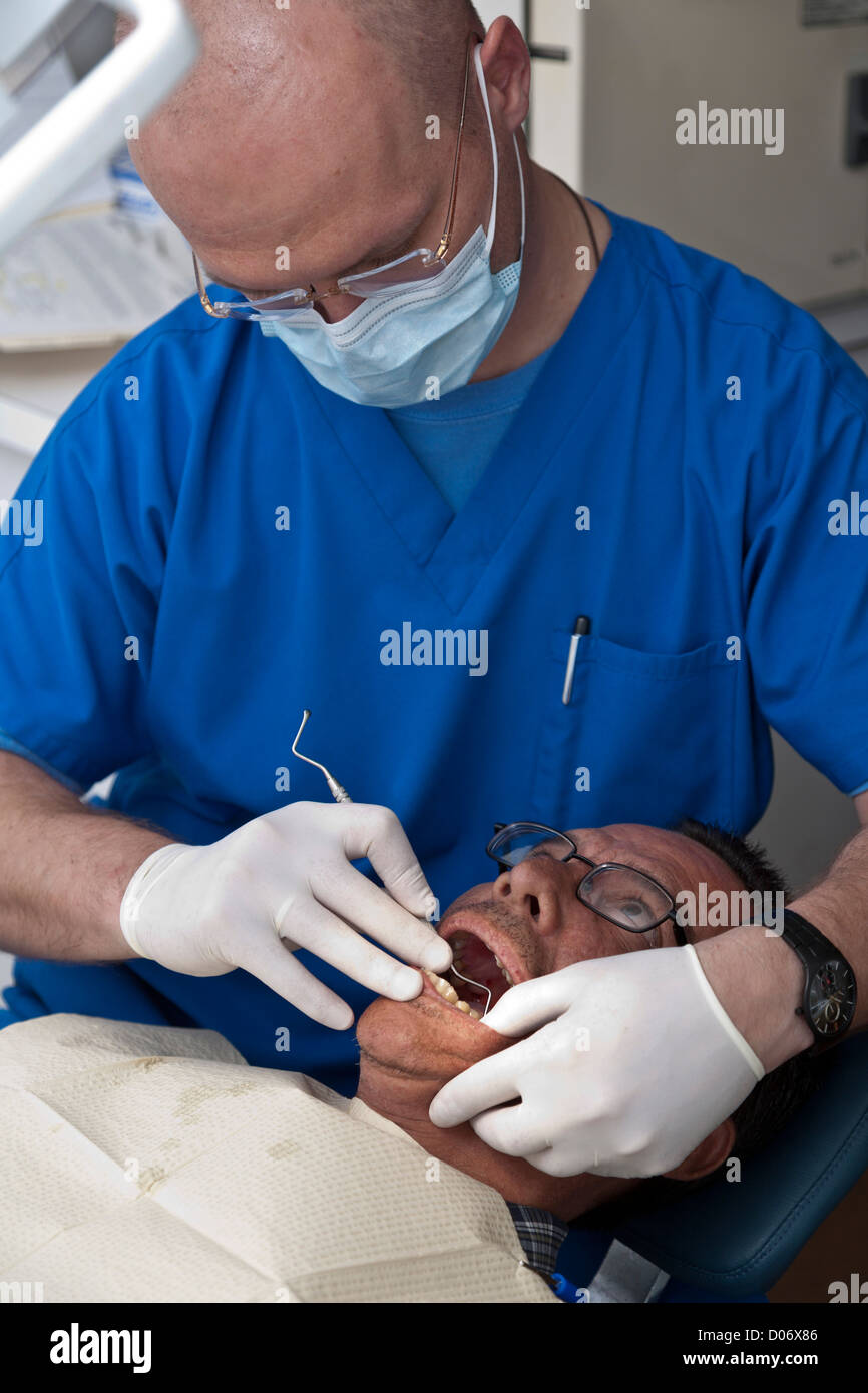 Maschio dentista volontari fornisce servizi dentali attraverso la missione sorrisi mobile clinica dentale a Tampa, FL Foto Stock