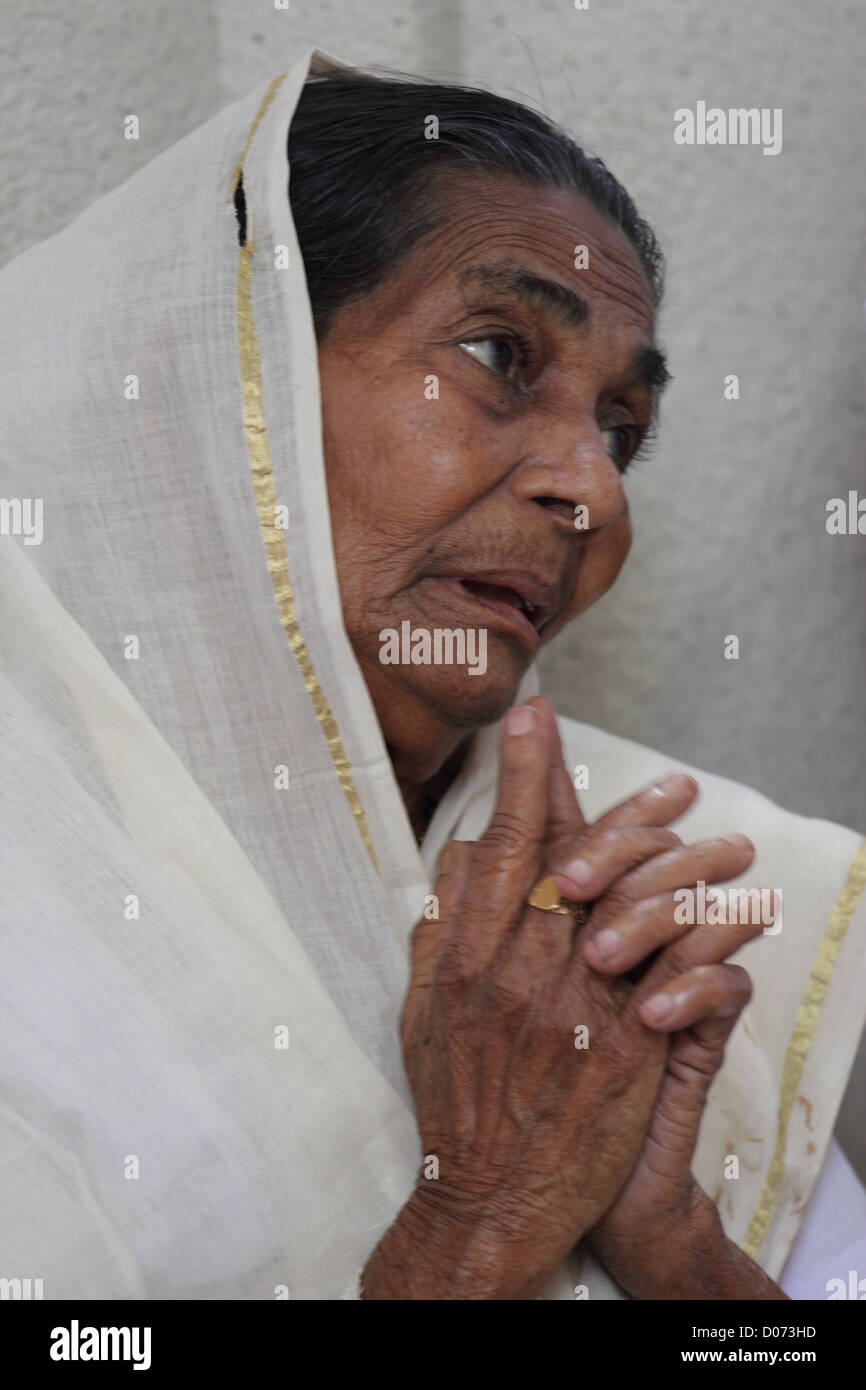 Immagine di una vecchia signora adorare Gesù alla Chiesa in Kerala. Foto Stock